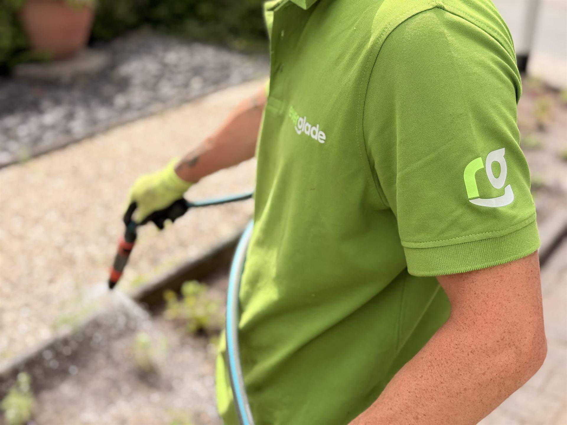 Mitarbeiter der Everglade GmbH bewässert ein frisch angelegtes Beet