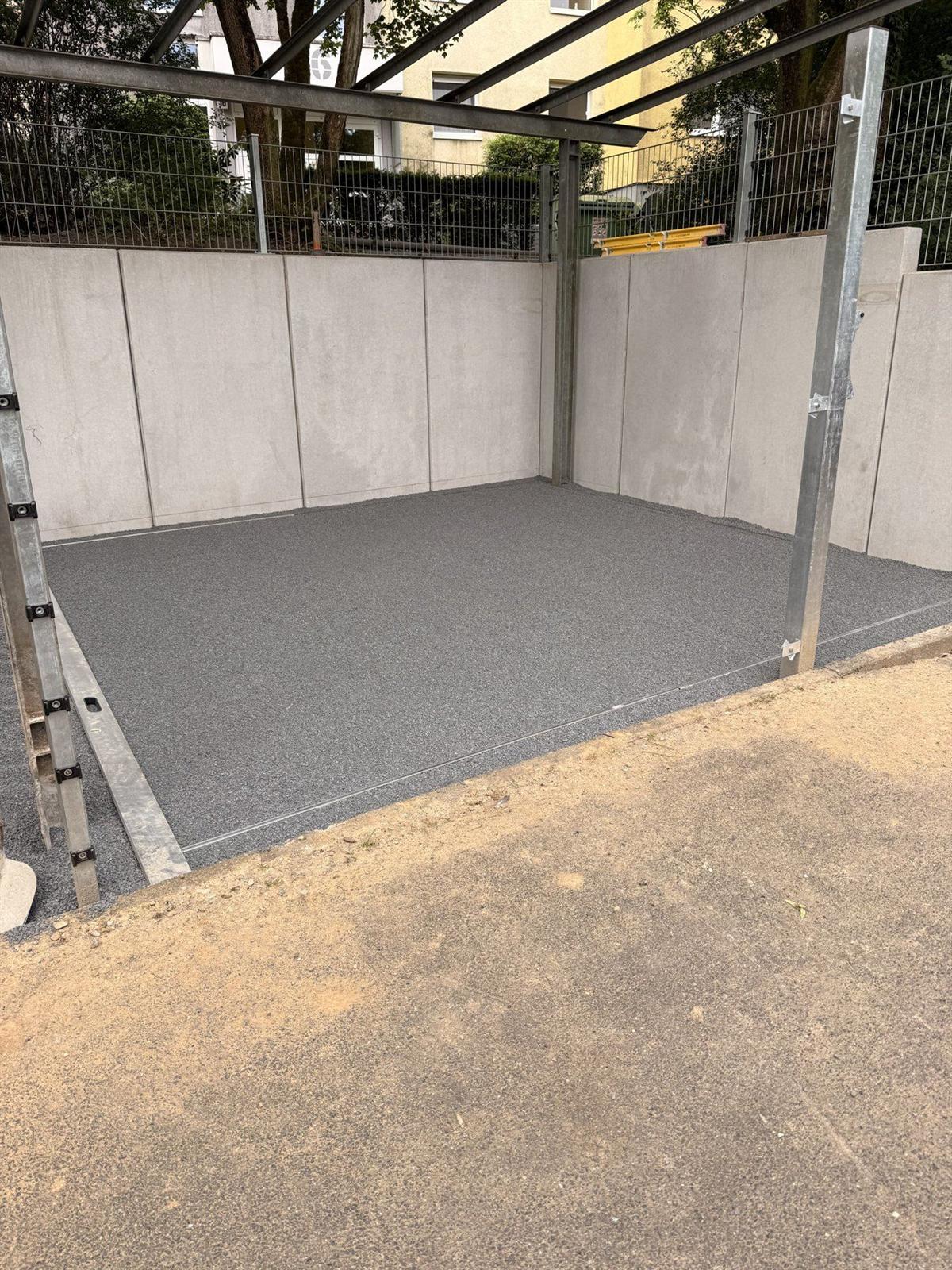 Frisch abgezogenes Splittbett als ebene Unterlage für einen neuen Belag, eingefasst von Winkelstützen aus Sichtbeton