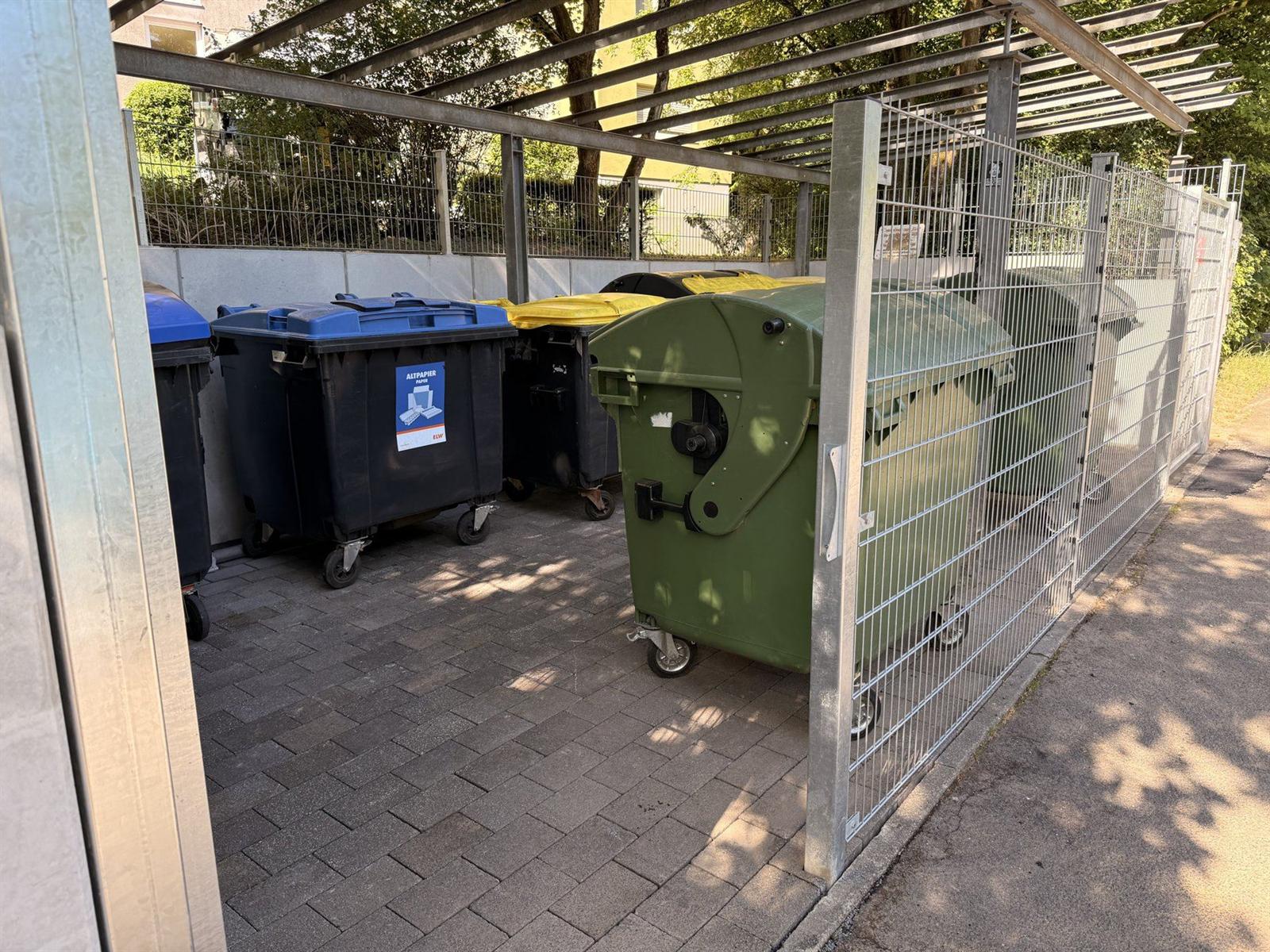 Müllcontainer auf dem erneuerten Stellplatz hinter dem Gittertor