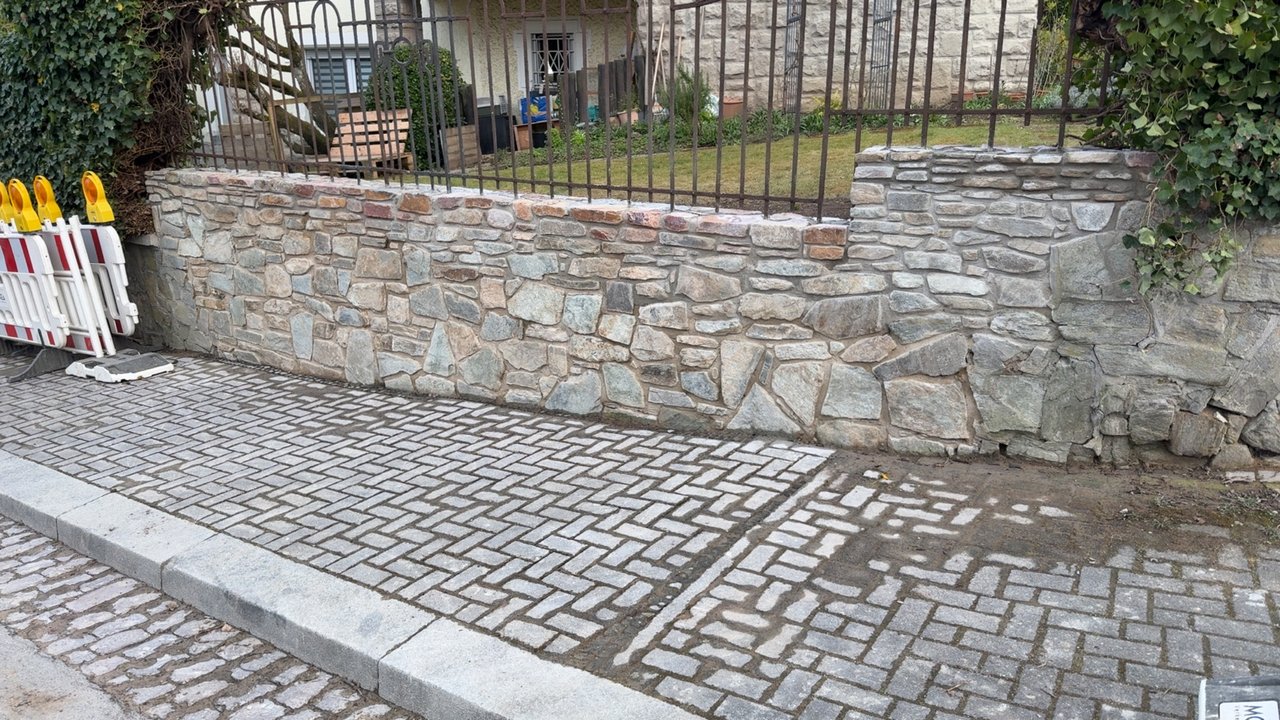 Wiederaufgebaute Natursteinmauer mit gepflastertem Gehweg in Wiesbaden