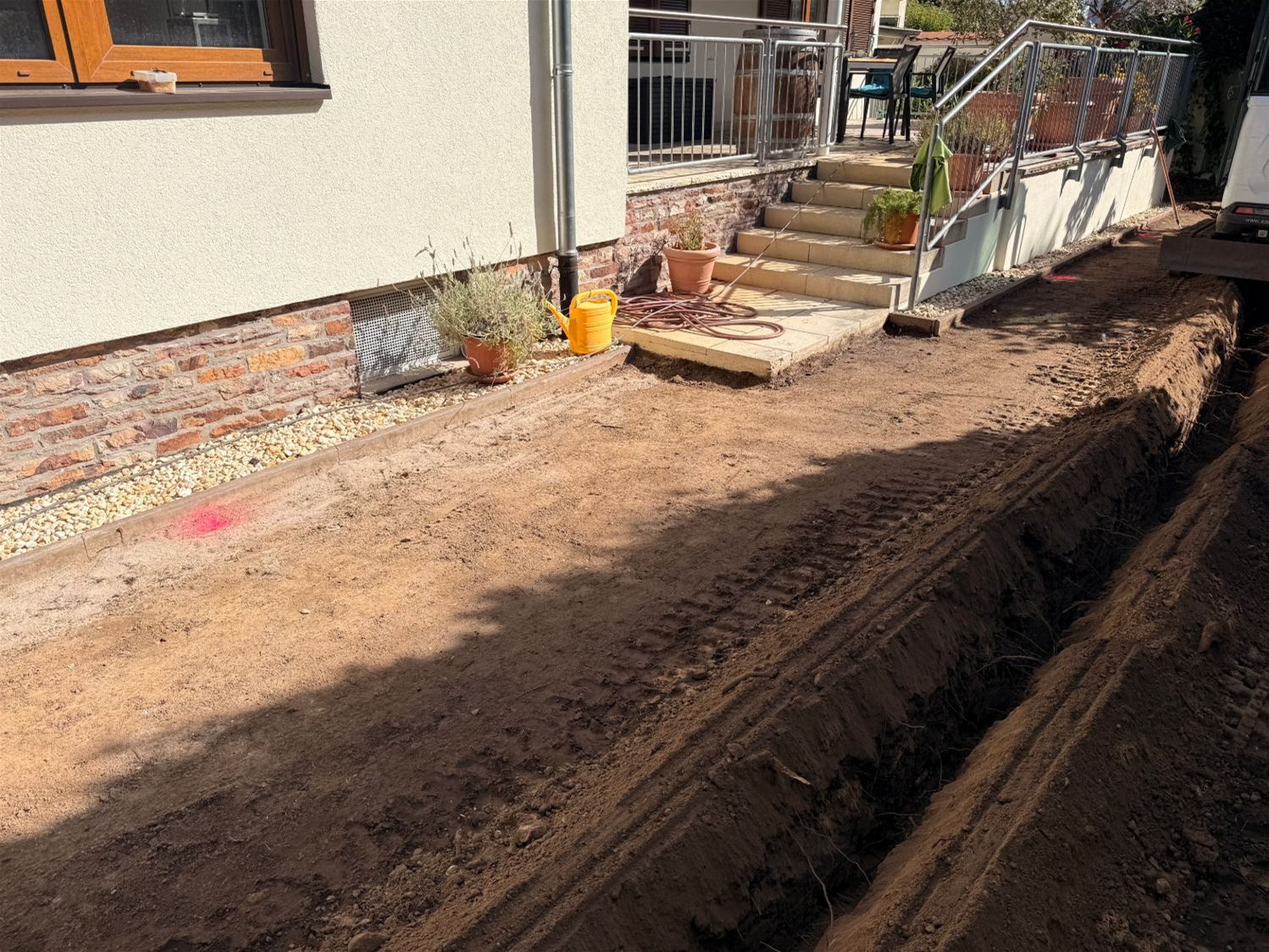 Abgetragene Rasenfläche mit Leitungsgraben entlang der Hauswand in Wiesbaden