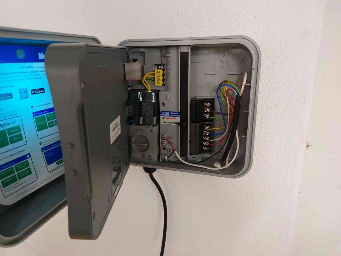 Geöffnetes Hunter-Steuergerät an der Wand mit Netzteil, Klemmleisten und farbigem Steuerkabel