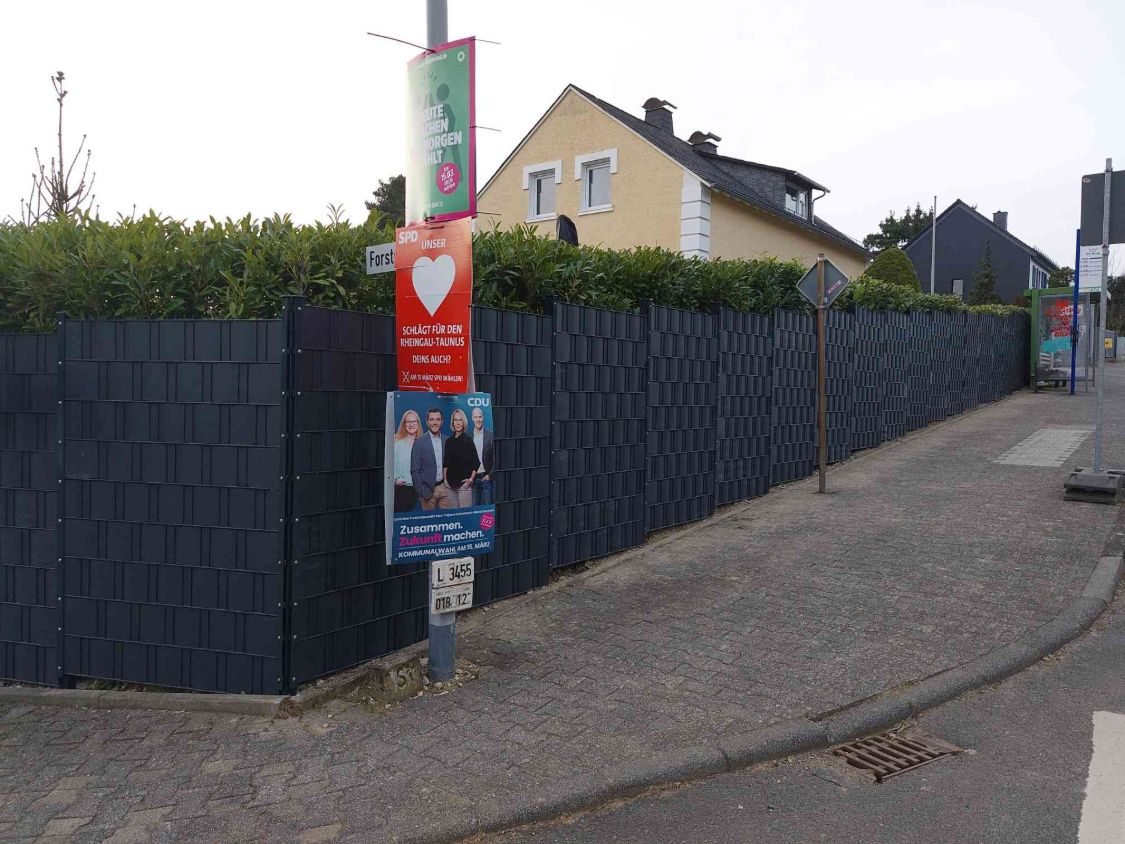 Zaun mit Sichtschutz entlang des Gehwegs bis zur Bushaltestelle