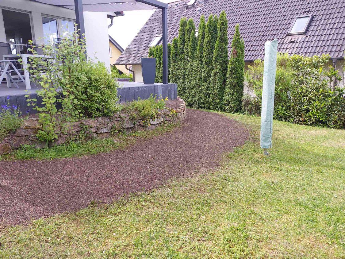 Frisch eingesäte Rasenfläche entlang der Trockenmauer