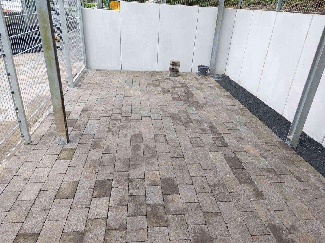 Wieder verlegtes altes Rechteckpflaster vor den Sichtbetonwänden