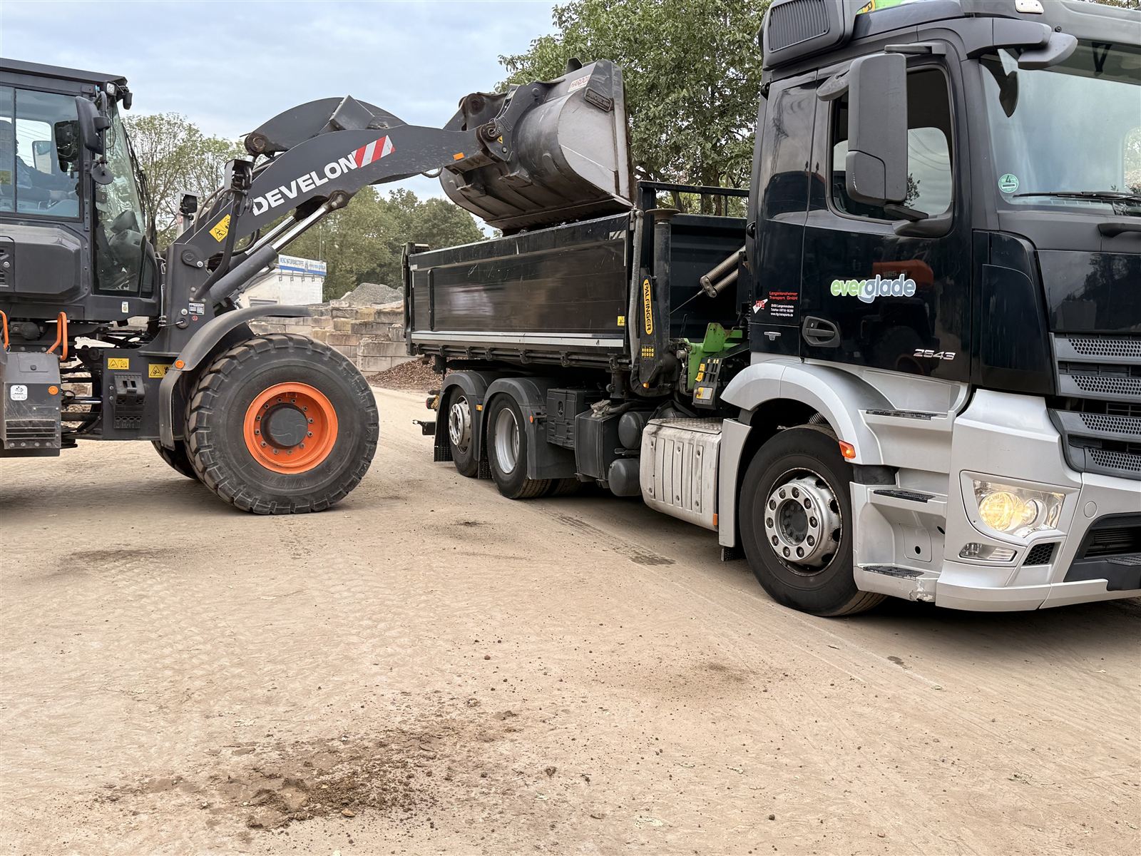 Radlader belädt einen Lkw der Everglade GmbH auf dem Lagerplatz