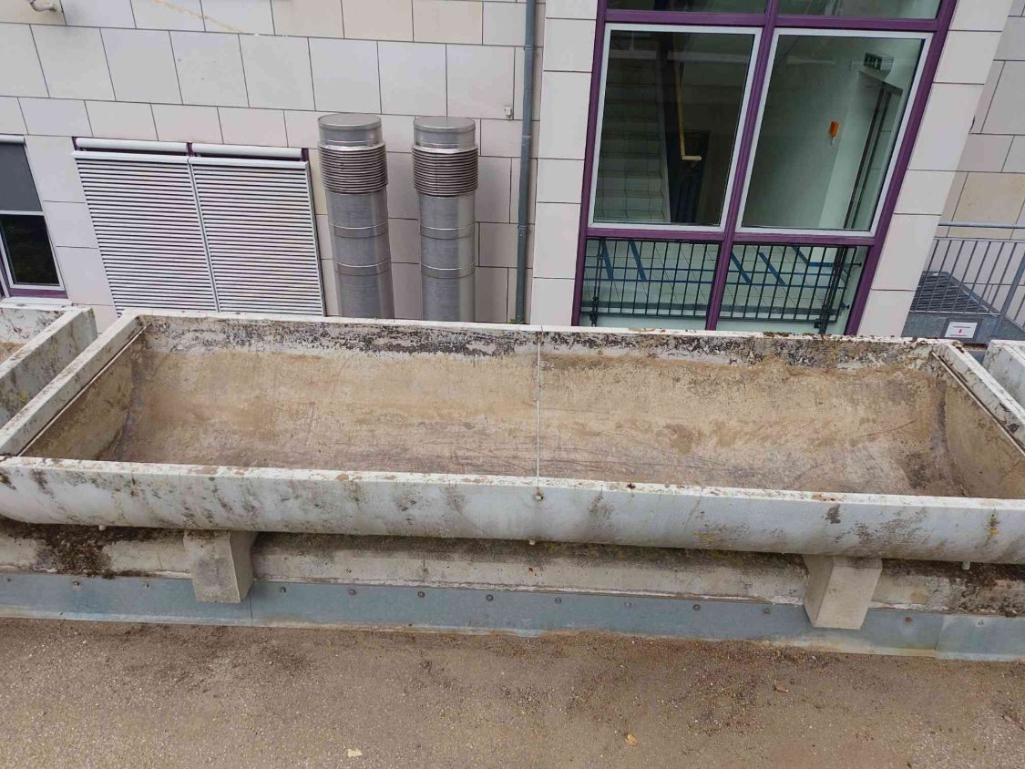 Leerer, besenrein gesäuberter Pflanzkübel aus Beton