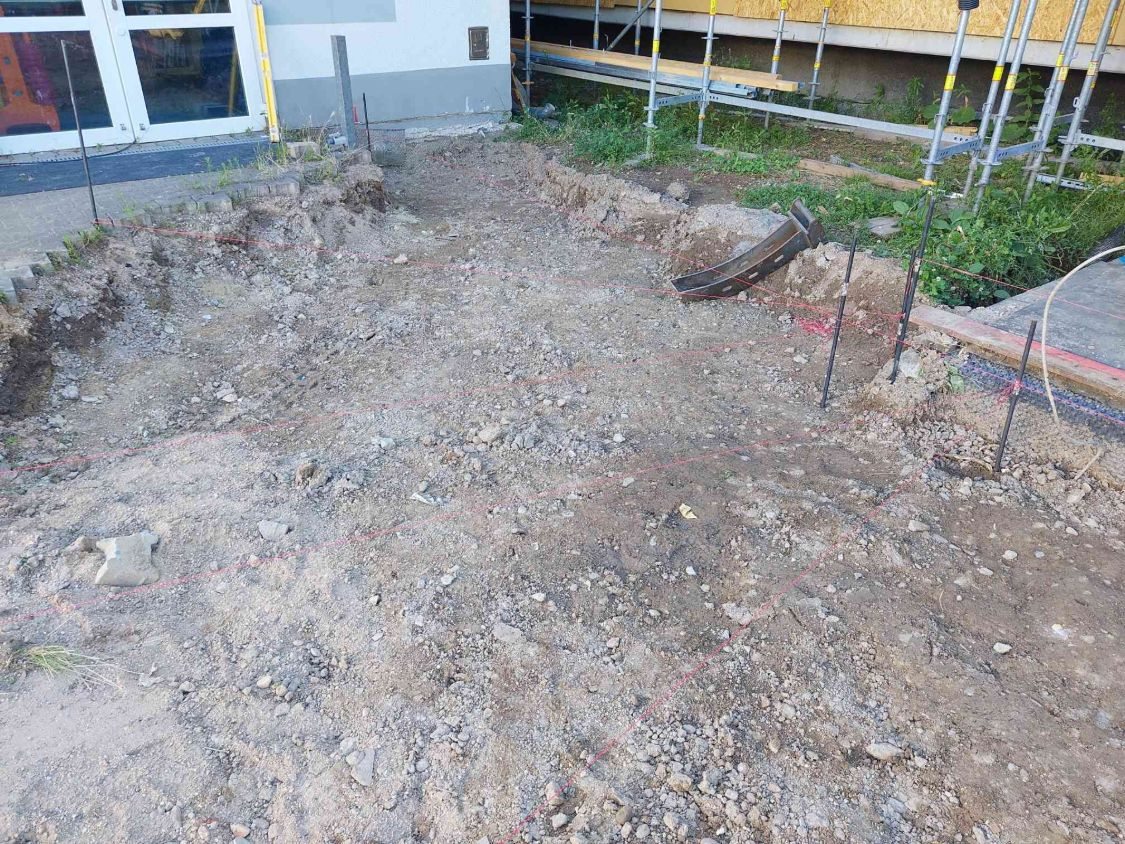 Ausgehobene Fläche mit gespannten Schnüren für Höhen und Fluchten