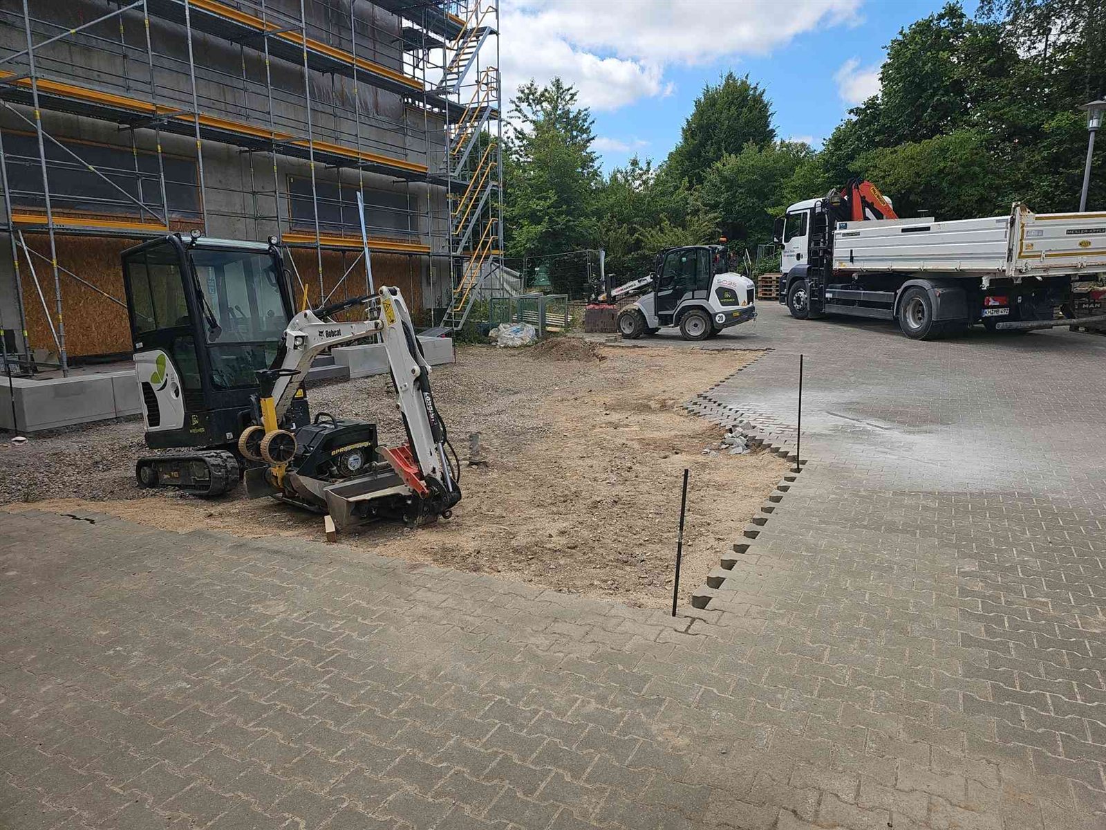 Minibagger, Radlader und Kran-Lkw der Everglade GmbH im Schulhof