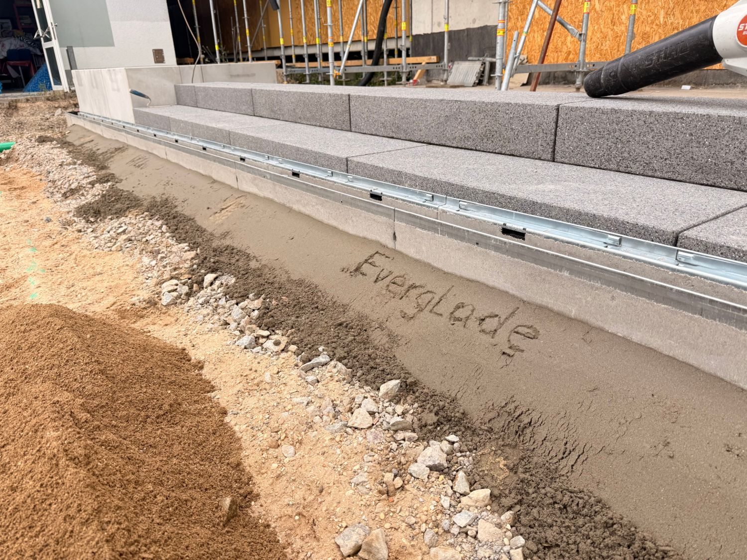 Rinne FASERFIX KS 100 mit verzinkter Kante vor den Stufen, im Sand davor steht Everglade geschrieben