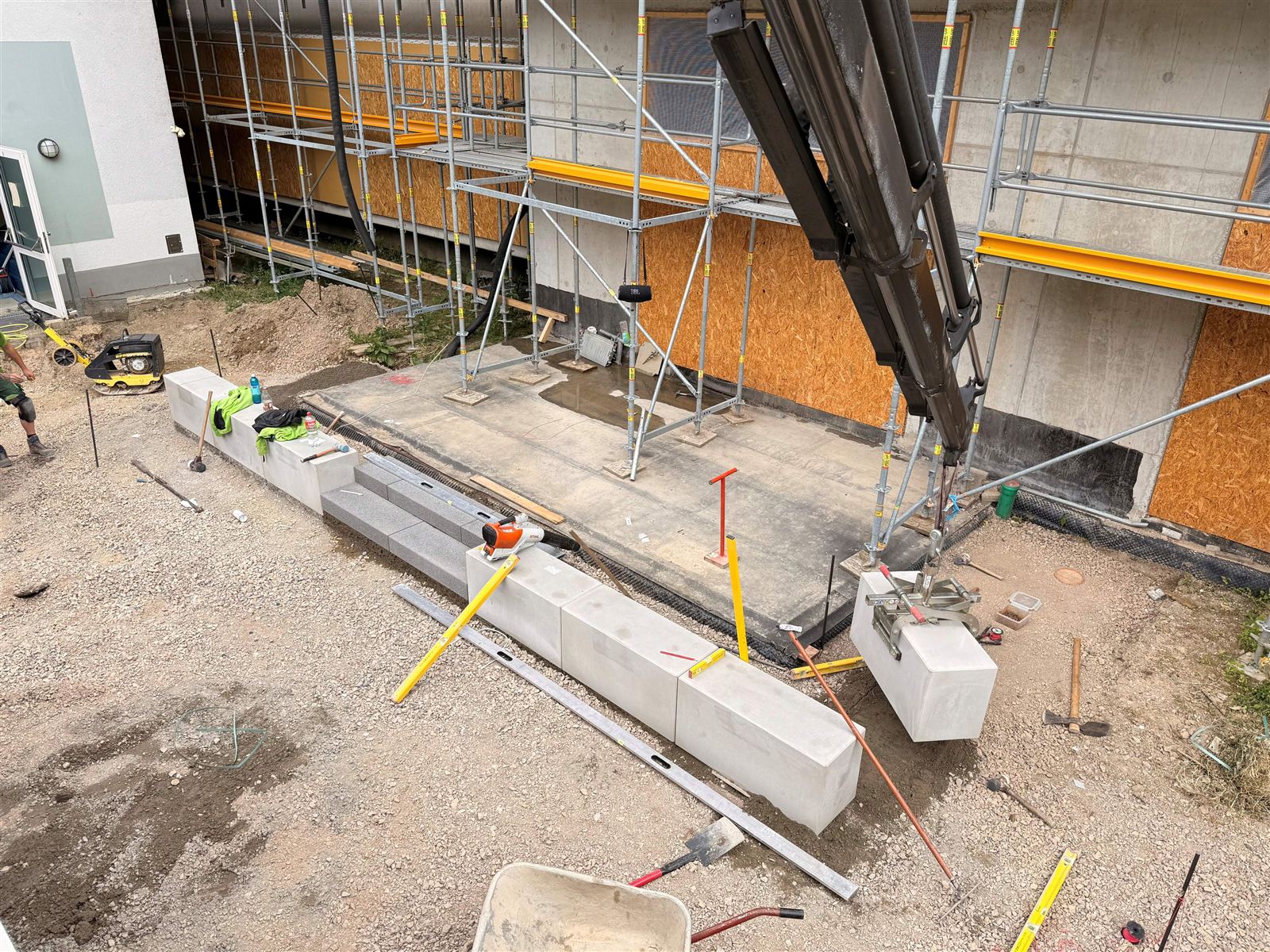 Winkelstützen aus Beton werden mit dem Kran vor einem Gebäude versetzt