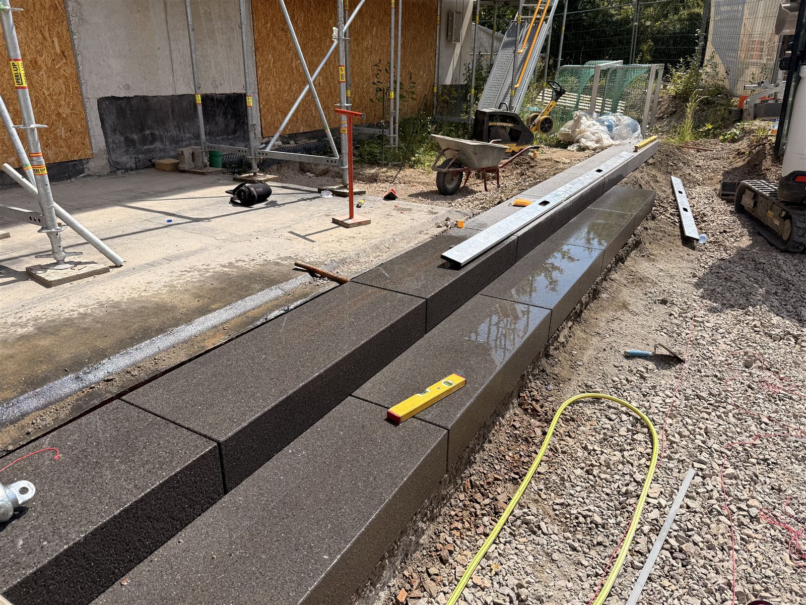 Frisch gesetzte Betonelemente, ausgerichtet mit Wasserwaage und Schnur